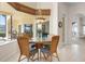 Bright breakfast nook features a glass table and chairs with views of the outdoor patio and pool at 872 Macaw Cir, Venice, FL 34285