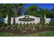 Pelican Pointe Golf & Country Club sign with manicured landscaping and lush greenery surrounding the entrance at 872 Macaw Cir, Venice, FL 34285