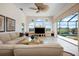 Bright living room with neutral tones, large windows, and access to the outdoor pool area at 872 Macaw Cir, Venice, FL 34285