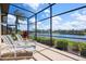 Screened patio with lounge chairs overlooking the pond provides a relaxing outdoor living space at 872 Macaw Cir, Venice, FL 34285