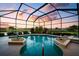 A private, screened in pool offers a relaxing retreat with a stunning sunset view at 872 Macaw Cir, Venice, FL 34285