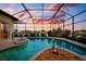 A private screened-in pool offers a serene retreat with picturesque sunset views at 872 Macaw Cir, Venice, FL 34285