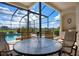 Outdoor patio area with a screened enclosure, offering scenic pool and garden views at 872 Macaw Cir, Venice, FL 34285