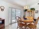 Bright dining room featuring wood table set and cabinet, with sliding glass doors at 985 Everest Rd, Venice, FL 34293