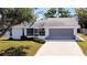 Charming single-story home with a gray roof, a 2-car garage, a cozy front porch, and well-maintained landscaping at 985 Everest Rd, Venice, FL 34293