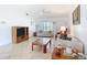 Cozy living room with neutral tile flooring, and comfortable seating, flooded with natural light from a large window at 985 Everest Rd, Venice, FL 34293