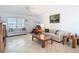 Bright living room featuring tile flooring, a ceiling fan, neutral-colored sofas, and a large window for natural light at 985 Everest Rd, Venice, FL 34293