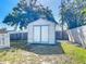 Storage shed with double doors in backyard surrounded by a privacy fence and landscaping at 985 Everest Rd, Venice, FL 34293