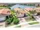 Stunning aerial view of a home near the lake featuring lush landscaping and a red tile roof at 10093 Cozy Grove Dr, Venice, FL 34293
