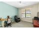 Inviting bedroom with large window, desk, cozy seating, and ample natural light, creating a warm atmosphere at 10093 Cozy Grove Dr, Venice, FL 34293