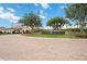 Sarasota National community entrance with brick paved drive and lush, manicured landscaping at 10093 Cozy Grove Dr, Venice, FL 34293