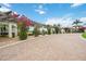 Elegant community entrance with flowering bougainvillea, a pergola, and a brick-paved drive at 10093 Cozy Grove Dr, Venice, FL 34293