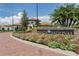 Community entrance with vibrant flowerbeds and elegant signage set against a backdrop of community buildings at 10093 Cozy Grove Dr, Venice, FL 34293