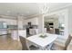 Bright dining room featuring decorative light fixture, mirror, and modern dining table with seating at 10093 Cozy Grove Dr, Venice, FL 34293