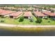 Waterfront homes with barrel tile roofs and screened in patios overlook the lake and backyard at 10093 Cozy Grove Dr, Venice, FL 34293