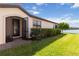 Front exterior showing a beautiful blue door, brick walkway, lush landscaping, and serene water views at 10093 Cozy Grove Dr, Venice, FL 34293