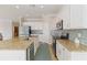 Spacious kitchen featuring granite countertops, white cabinetry, stainless steel appliances, and tile floors at 10093 Cozy Grove Dr, Venice, FL 34293
