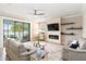 This bright living room has tile floors, stylish furniture, a modern fireplace, and serene lake views at 10093 Cozy Grove Dr, Venice, FL 34293