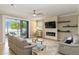 Bright living room showcases tile floors, stylish furnishings, a modern fireplace, and serene lake views at 10093 Cozy Grove Dr, Venice, FL 34293