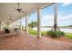 Expansive covered patio with brick flooring and lake views; perfect for outdoor entertaining at 10093 Cozy Grove Dr, Venice, FL 34293