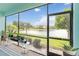 Serene screened porch overlooking a tranquil lake, providing a relaxing outdoor space with scenic water views at 10093 Cozy Grove Dr, Venice, FL 34293