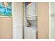 A functional laundry area inside the bathroom, complete with a stacked washer and dryer unit and storage at 1018 Wexford Blvd # 1018, Venice, FL 34293
