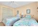 Bright bedroom featuring two twin beds, closet storage, and modern lighting at 1018 Wexford Blvd # 1018, Venice, FL 34293
