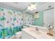 Bright bathroom with a turtle themed shower curtain, white vanity, and framed mirror at 1018 Wexford Blvd # 1018, Venice, FL 34293
