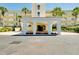 Inviting building entrance with colorful flowers and tropical palm trees creates a warm welcome at 1018 Wexford Blvd # 1018, Venice, FL 34293