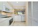 View of kitchen with appliances, lighting, and open to dining and living areas with mirrored wall at 1018 Wexford Blvd # 1018, Venice, FL 34293