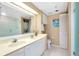 Bright bathroom features double sinks, a washer/dryer unit, and a glass-enclosed shower at 1018 Wexford Blvd # 1018, Venice, FL 34293