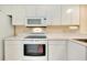 All-white kitchen with matching oven, microwave, and cabinets offer abundant storage at 1018 Wexford Blvd # 1018, Venice, FL 34293