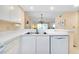 Bright kitchen featuring a stainless steel sink, dishwasher, and view to the adjacent dining and living room at 1018 Wexford Blvd # 1018, Venice, FL 34293