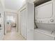 Hallway area with stacked white washer and dryer and linen closet at 1025 Capri Isles Blvd # 18, Venice, FL 34292