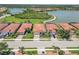 Aerial view of a neighborhood showing homes with tile roofs and a large lake in the background at 10618 Corkwood Ct, Venice, FL 34293