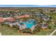 Stunning aerial view of the community pool, clubhouse, tennis courts, and lush tropical landscaping at 10618 Corkwood Ct, Venice, FL 34293