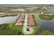 Aerial view of a residential community with tile-roofed homes nestled among lakes and green spaces at 10618 Corkwood Ct, Venice, FL 34293