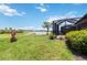 Lush backyard with mature plants leading to a lake beyond screened-in lanai at 10618 Corkwood Ct, Venice, FL 34293