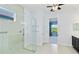 Modern bathroom featuring a glass-enclosed shower with tile surround, with view to the bedroom at 10618 Corkwood Ct, Venice, FL 34293