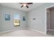 Bedroom with grey walls, a window with blinds, ceiling fan, and doorway to another room at 10618 Corkwood Ct, Venice, FL 34293