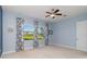 Cozy bedroom with blue walls, ceiling fan, two windows with floral drapes and outside lawn views at 10618 Corkwood Ct, Venice, FL 34293