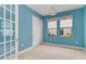Bedroom with blue walls, two windows, a closet, and a door to another room at 10618 Corkwood Ct, Venice, FL 34293