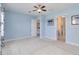 Bedroom with blue walls, white trim, a ceiling fan and views of an ensuite bathroom at 10618 Corkwood Ct, Venice, FL 34293