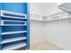Custom closet with shelving on both sides. One side is blue with built in shelves at 10618 Corkwood Ct, Venice, FL 34293