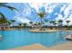 Inviting community pool with comfortable lounge chairs, palm trees, and clear blue skies, perfect for leisure at 10618 Corkwood Ct, Venice, FL 34293
