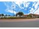 Sarasota National entrance sign, beautifully landscaped, with palm trees and clear blue skies at 10618 Corkwood Ct, Venice, FL 34293