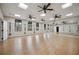 Bright fitness room with wood floor, ceiling fans, large mirror and equipment for exercise at 10618 Corkwood Ct, Venice, FL 34293