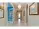 Elegant hallway with arched doorways, tile flooring, chandelier, and stylish decor leading to a bright room at 10618 Corkwood Ct, Venice, FL 34293