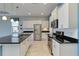 Well-lit kitchen featuring white cabinets, granite countertops, stainless steel appliances, and tile flooring at 10618 Corkwood Ct, Venice, FL 34293