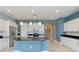 Bright, modern kitchen with white cabinets, stainless steel appliances, black countertops, and a stylish island at 10618 Corkwood Ct, Venice, FL 34293